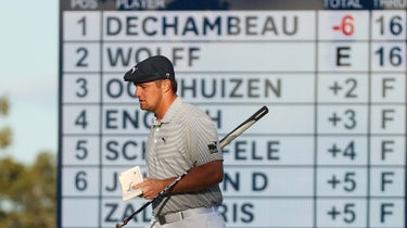 bryson dechambeau walks with scoreboard