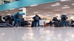 Travelers await for their bags at an airport.