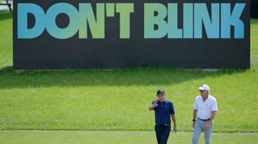 greg norman walks in front of liv billboard