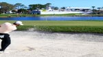 golfer hits greenside bunker shot